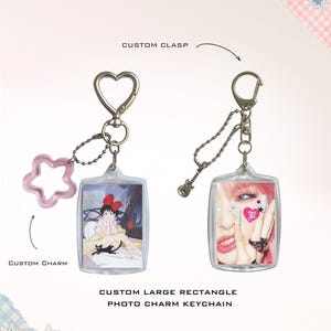 Peut inclure: Deux porte-clés photo rectangulaires personnalisés avec des accessoires en argent. L'un possède un fermoir en forme de cœur et une breloque étoile rose, l'autre une breloque guitare. Les porte-clés présentent des images et des étiquettes.