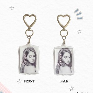 May include: Two rectangular acrylic keychains featuring a black and white portrait of a woman with the text Lana printed vertically. Each keychain has a silver-toned metal heart-shaped clasp and a swivel ring attachment for secure fastening.