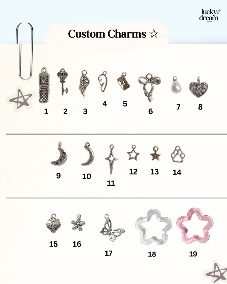 May include: A collection of custom charms, including a star, a flip phone, a key, wings, an envelope, a bow, a pearl, a heart, a crescent moon, a star, a paw print, a flower, a butterfly, and star shapes. The text "Custom Charms" is visible.