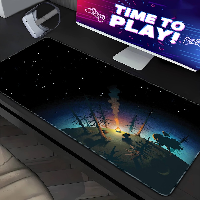 May include: A black gaming mouse pad with a starry night sky design. The mouse pad features a campfire scene with trees and a glowing fire. The text "Time to Play!" is visible in the background.