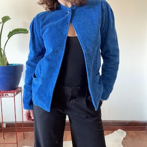 May include: A blue corduroy jacket with a single button closure and a stand-up collar.