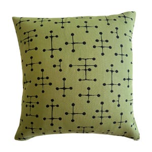 May include: A green throw pillow with a black geometric pattern. The pattern is made up of small circles and lines.