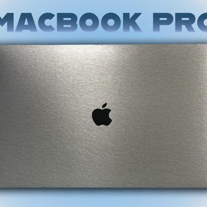 以下が含まれることがあります： 蓋にアップルのロゴが付いたシルバーのMacBook Proラップトップ