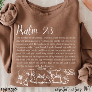May include: Espresso-colored sweatshirt with the text "Psalm 23" in a script font. The text of the Psalm is printed below, along with a graphic of sheep. The sweatshirt is a Comfort Colors 1466.