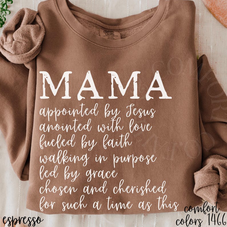 May include: Espresso-colored sweatshirt with the word "MAMA" in large white letters. Below, the text reads "appointed by Jesus, anointed with love, fueled by faith, walking in purpose, led by grace, chosen and cherished for such a time as this."