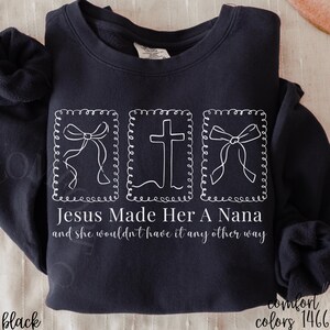 Pu&ograve; includere: Felpa nera con grafica bianca. Il design include due fiocchi e una croce all'interno di cornici decorative, con la scritta "Jesus Made Her A Nana and she wouldn't have it any other way". La felpa &egrave; di Comfort Colors.