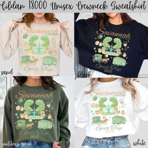 May include: Crewneck sweatshirts in sand, black, military green, and white. Each shirt features a graphic with the text "Savannah Georgia Girls Trip 2025" and illustrations of a fountain, carriage, and trolley.