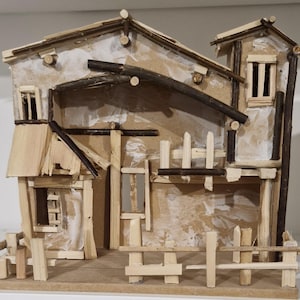 May include: A handmade miniature house model made from wood and twigs. The rustic building features a fence, multiple windows, and a textured facade. The roof is made of small branches, and the design evokes a charming, rural aesthetic.