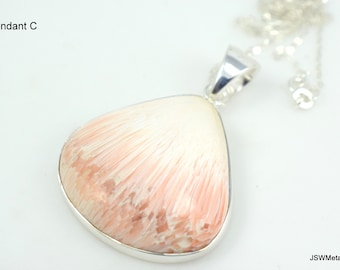 Op de afbeelding: Een zilveren hanger met een roze en witte gefossiliseerde koraal in een traanvorm.