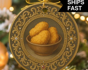 May include: Round Christmas ornament with a detailed gold and green border. The center features a bowl of golden fried chicken nuggets. The ornament has a gold ribbon for hanging and the text "SHIPS FAST" in a black banner.
