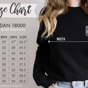 Puede incluir: Sudadera negra Gildan 18000 de mezcla pesada con una tabla de tallas. La tabla muestra medidas en pulgadas para el ancho, el largo y el largo de la manga, que van desde la talla S hasta la 5XL. La imagen tambi&eacute;n muestra las medidas de ancho y largo.