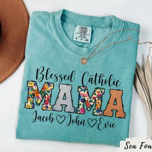 Chemise pour maman catholique bénie Tee-shirt personnalisé pour enfants, motifs floraux, couleurs de confort, cadeau de fête des mères religieux pour anniversaire de maman, t-shirt personnalisé