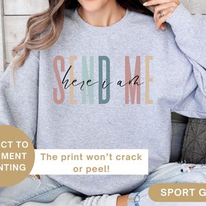 May include: A gray sweatshirt with the text "Send Me Here I Am" in rainbow colors. The print is direct to garment and won't crack or peel.