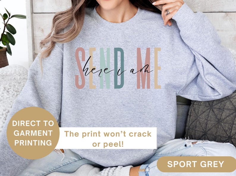 May include: A gray sweatshirt with the text "Send Me Here I Am" in rainbow colors. The print is direct to garment and won't crack or peel.