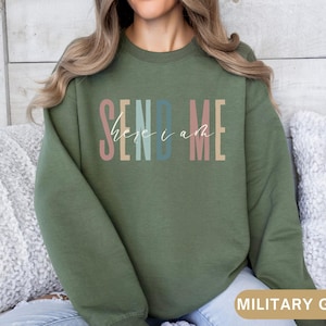 May include: A green sweatshirt with the text "SEND ME here i am" in colorful letters.