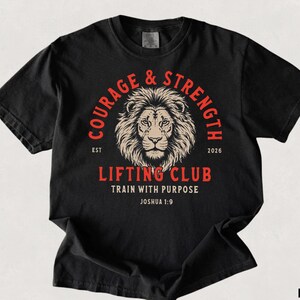 May include: Black t-shirt with a lion's head graphic and the words "Courage & Strength" in a circular design. Below the lion is "Lifting Club" and "Train with Purpose". The shirt also has the text "Joshua 1:9".