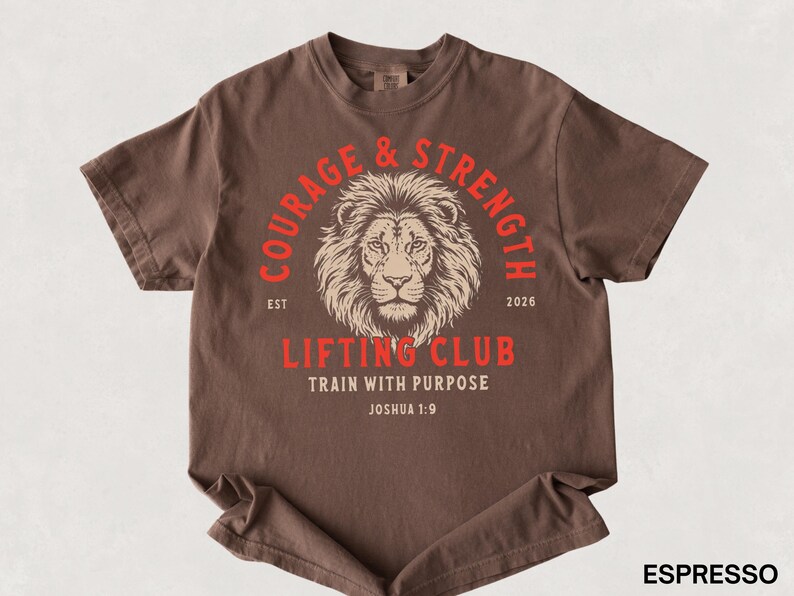 May include: Espresso-colored t-shirt with a lion graphic and the words "Courage & Strength Lifting Club" in red. The shirt also includes the text "Train with Purpose" and "Joshua 1:9".