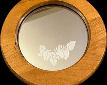 Espelho de parede redondo de 28 cm (11") com acabamento em carvalho vintage e detalhes florais gravados no vidro.