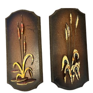 Set of Two Midcentury Metal Brutalist Decorative Art Wall Hangings, Featuring a Nature Inspired Theme, Showcasing Cattails and Reeds.