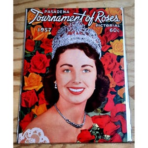 May include: A vintage 1957 Pasadena Tournament of Roses Pictorial magazine cover featuring a woman wearing a crown and a white lace dress. The cover is adorned with red and yellow roses.