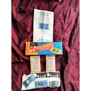 May include: A blue and white box with the text "Roundhouse Products" and "Model R.R. Equipment". The box contains a model train car kit with instructions and parts. The instructions are labeled "A Roundhouse Product No Car Sides Hopper Ore Car 100 Line".