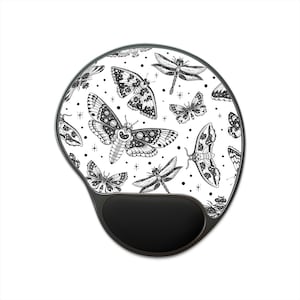 May include: A black and white mouse mat with a pattern of butterflies and dragonflies. The mouse mat has a black wrist rest.