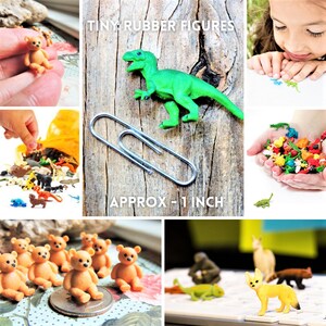 May include: A collection of tiny rubber animal figures, including a dinosaur, bear, fox, and other animals. The figures are approximately 1 inch tall and are shown next to a paperclip for size comparison.  The text "TINY RUBBER FIGURES" and "APPROX - 1 INCH" is visible in the image.