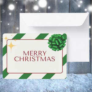 Könnte beinhalten: Eine weiße Karte mit grünen und roten Streifen und einer grünen Schleife. Die Karte sagt "Frohe Weihnachten".