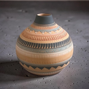 May include: A handcrafted, round pottery vase with a dark grey neck and a light brown body. The vase features intricate geometric patterns in black, orange, and blue, with a textured surface. The design includes stylized mountain and animal motifs.