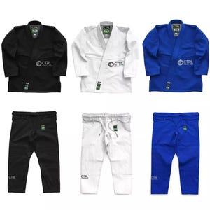 May include: Three sets of black, white, and blue jiu-jitsu uniforms. Each set includes a jacket and pants. The jackets have a black, white, or blue color with the word "CTRL" printed on the chest and back. The pants have a black, white, or blue color with the word "CTRL" printed on the left leg.
