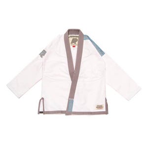Pode incluir: Gi branco de Jiu-Jitsu com detalhes cinzentos e azuis. O Gi tem um patch com a letra "R" no lado esquerdo do peito. O Gi é feito pela marca "Airmore Pro".