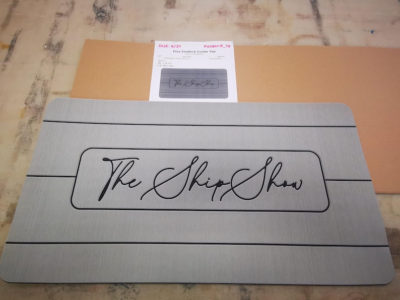 May include: Gray non-slip mat with black lines and the text "The Ship Show" in a cursive font.