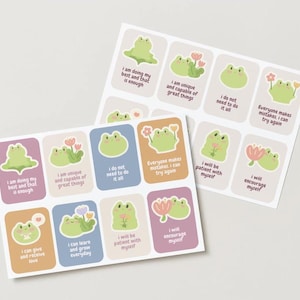May include: Two sheets of stickers with adorable green frog illustrations and motivational quotes. The stickers have pastel-coloured backgrounds and include phrases such as "I am unique and capable of great things."