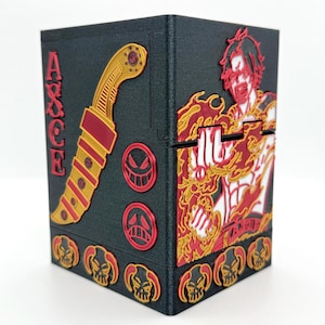 May include: Black box featuring red and gold accents. The box has a knife design and the word "ACE" in red. A character illustration with flames is on the side. The box has a series of skull designs.