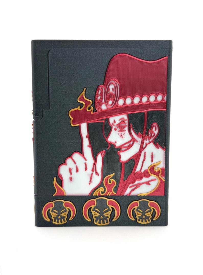May include: Black case featuring a red and gold illustration of a character with a hat and goggles. The character is pointing with one finger. The bottom of the case has three skull designs.