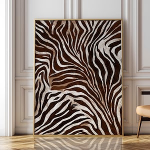 Peut inclure: Une œuvre d'art murale rectangulaire présentant un motif zébré à fort contraste avec des rayures ondulées brun foncé et blanc cassé. L'œuvre est encadrée par un fin cadre en métal doré, offrant un design graphique audacieux et organique.