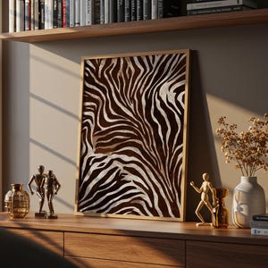 Peut inclure: Une œuvre d'art murale rectangulaire encadrée présentant un motif de rayures de zèbre à fort contraste en brun foncé et blanc. L'impression est présentée dans un cadre en bois clair, mettant en valeur des lignes fluides et organiques.