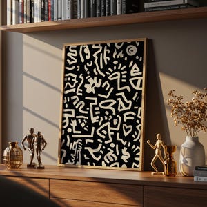 Peut inclure: Une œuvre d'art murale rectangulaire encadrée présentant un fond noir avec un motif dense et répétitif de formes, de lignes et de symboles abstraits dessinés à la main en blanc cassé. Le cadre est en bois clair, contrastant avec l'impression.