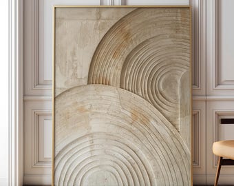 May include: A rectangular wall art piece featuring a textured, beige-toned surface with carved, concentric circular patterns. The artwork is encased in a thin, metallic gold frame, displaying a layered, relief-style design with subtle shadows.