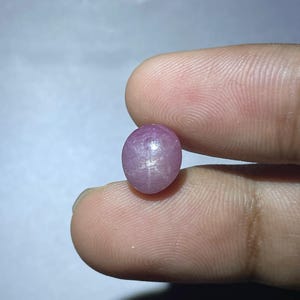 Op de afbeelding: Een roze ster-robijn cabochon edelsteen met een zespuntige ster.