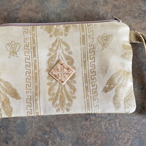 Bolso pequeño estampado dorado con cremallera y asa. Tamaño del teléfono celular. Bueno para una cartera, bolsa de maquillaje, etc. Forro de poliéster de bronce.