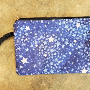 Bolso pequeño azul con estrellas plateadas con forro plateado y cremallera y asa. Tamaño de teléfono celular bueno para una cartera, bolsa de maquillaje, etc.
