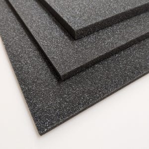 Könnte beinhalten: Drei Blätter schwarzer Schaumstoffpolsterung, übereinander gestapelt. Der Schaumstoff hat eine strukturierte Oberfläche.