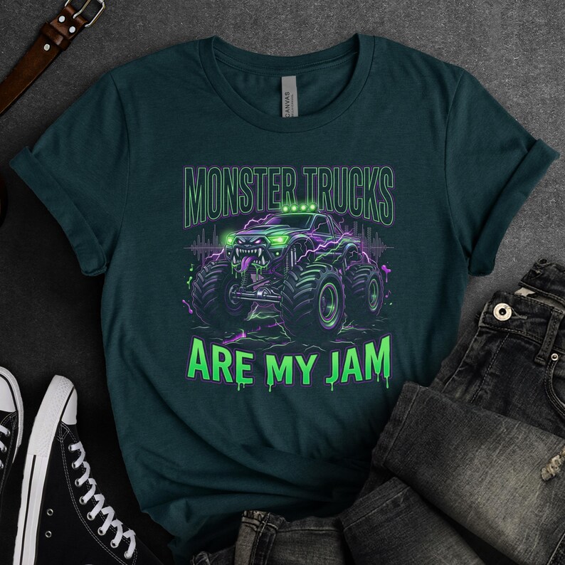 Pu&ograve; includere: T-shirt verde scuro con grafica di monster truck verde neon e viola e la scritta "MONSTER TRUCKS ARE MY JAM". La grafica include un'illustrazione dettagliata di un monster truck con pneumatici grandi e un volto ringhioso.