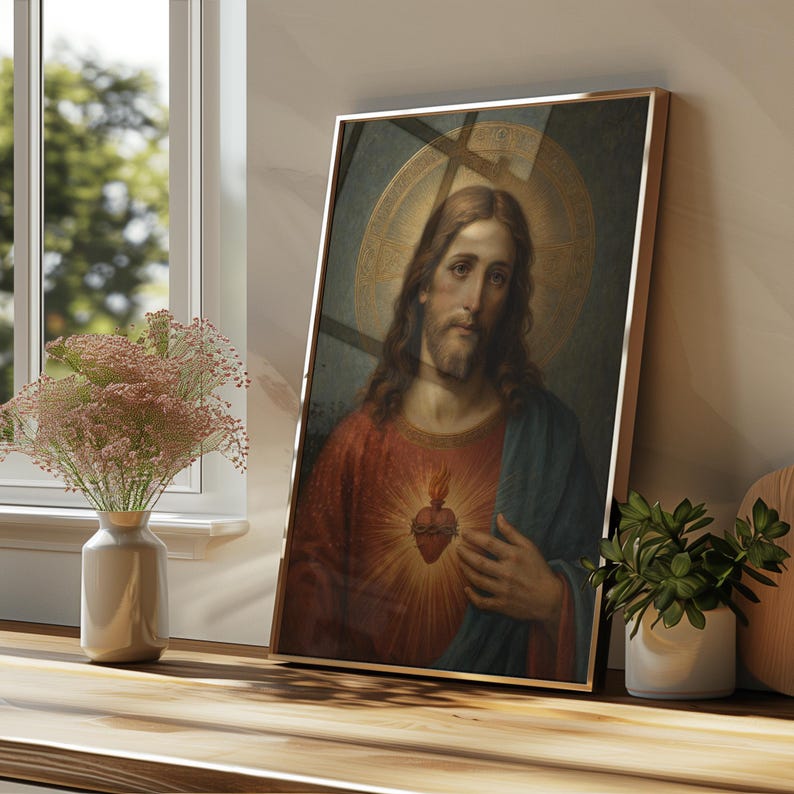 May include: A framed vertical wall art print depicting a portrait of a figure with long brown hair and a beard, wearing a red tunic and blue cloak, featuring a glowing heart emblem on the chest and a circular golden halo against a dark background.