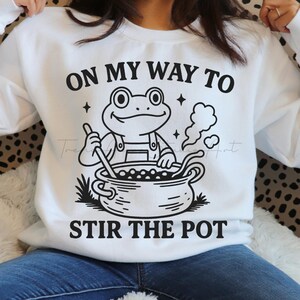 Rana divertida revolviendo olla PNG: Meme humorístico (Descarga digital)