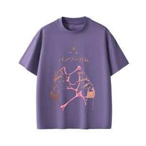 Pu&ograve; includere: T-shirt viola a maniche corte con scollo tondo. Il davanti presenta un design grafico con elementi dorati e rosa e testo giapponese. La maglietta ha una vestibilit&agrave; ampia.