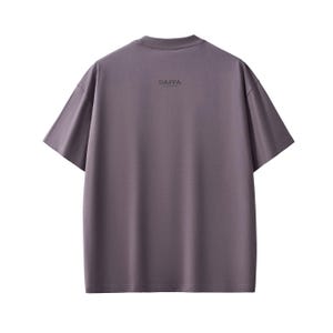 Pu&ograve; includere: Una maglietta tinta unita color malva con maniche corte. La parola "DAPPA" &egrave; stampata in un piccolo carattere scuro sulla parte superiore della schiena della maglietta. Ha un girocollo e una vestibilit&agrave; ampia, adatta all'abbigliamento casual.