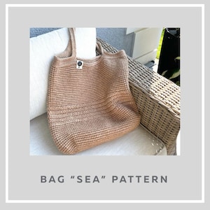 May include: A beige crocheted tote bag with a black circle logo. The bag is sitting on a white wicker chair with a white cushion. The text "BAG "SEA" PATTERN" is below the image.