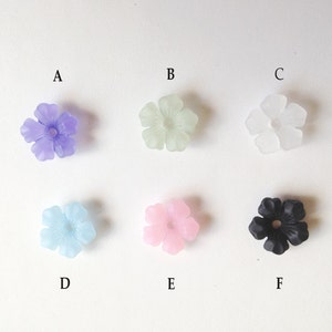 May include: Six flower-shaped beads in different colors: purple, light green, clear, light blue, pink, and black.
